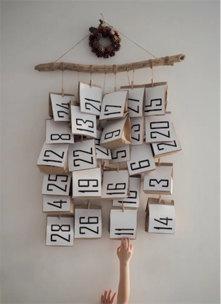 Wall calendar of numbered paper bags hanging from a branch