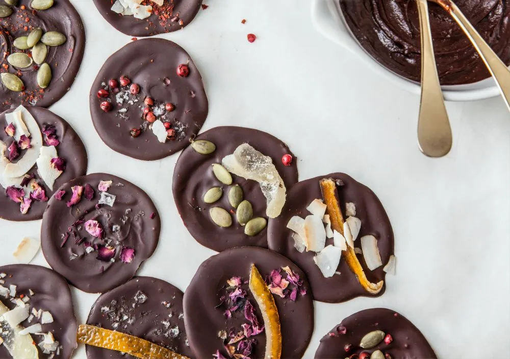 Chocolate discs topped with pistachios, dried fruit and petals
